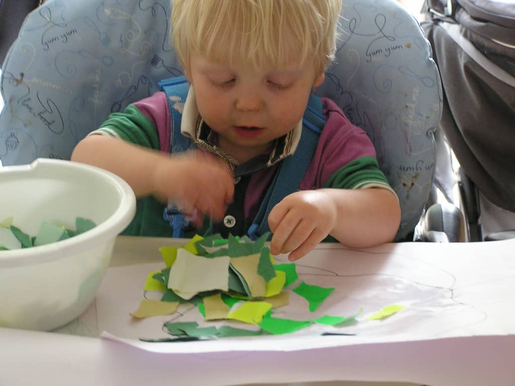 toddler tearing up paper for different crafts