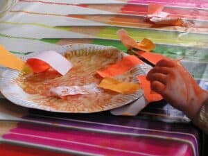 adding torn paper to a paper plate