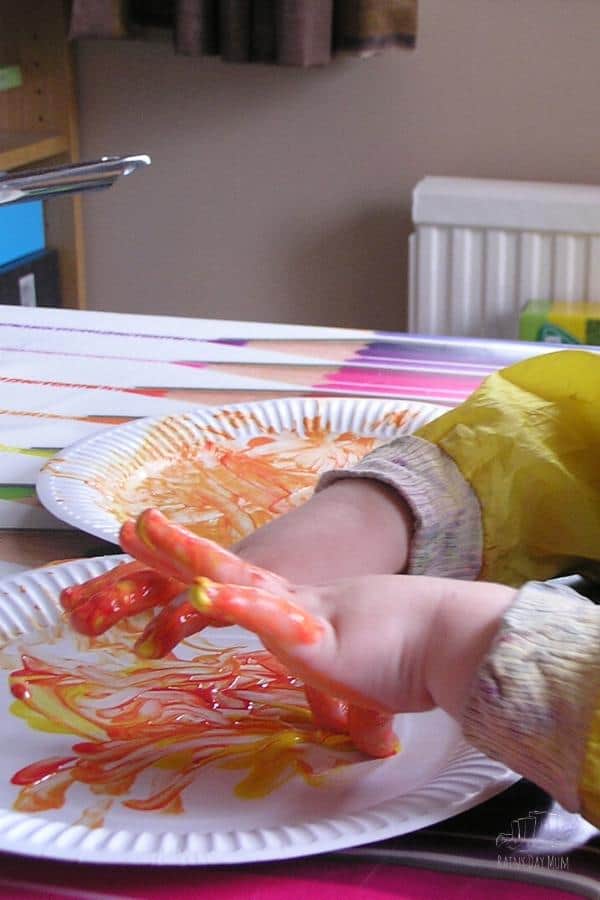 toddler finger painting a sensory aspect of crafts with tots