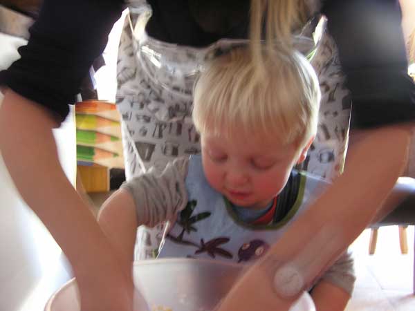 toddler and mum mixing rock cakes up in a bowl.