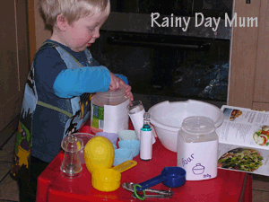 Toddler measuring ingredients using cups