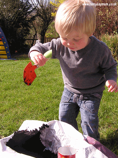 Toddler digging in compost to plant seeds
