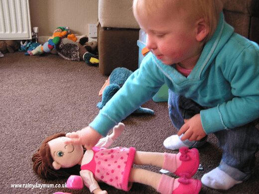 giving doll some tea imaginative play