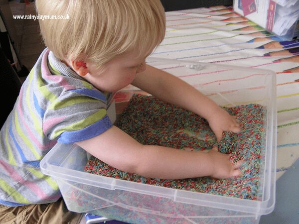 mixing up colours in rice sensory tub