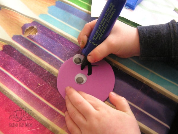 toddler painting egg boxes to create egg box caterpillars that will then grow