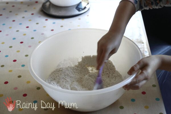 preschooler mixing the dry ingredients for bread making