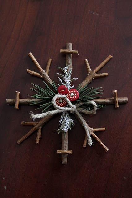 simple ornament for the christmas tree made from twigs with twine, buttons and pine needles