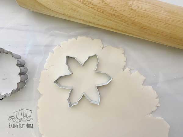 cutting out snowflakes from cornstarch clay