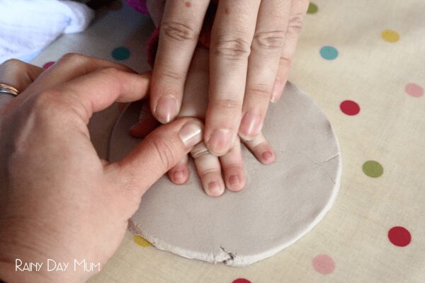 making a baby handprint in diy clay for a christmas decoration