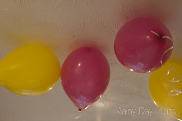 helium balloons with ribbon floating on an artex ceiling