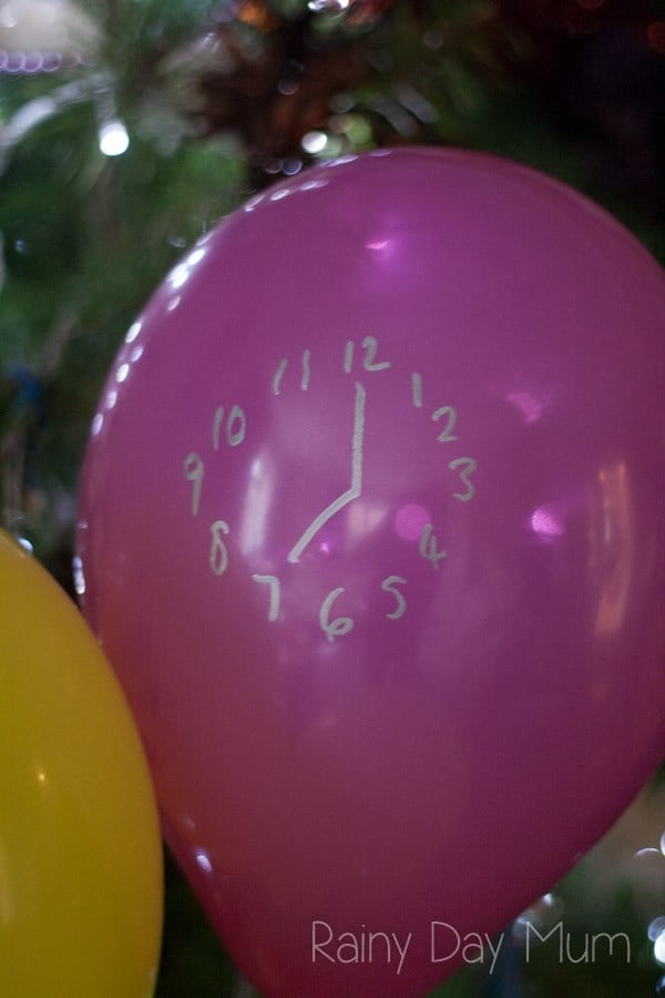 pink balloon with a silver clock on it showing 7 o'clock for counting down the hours to New Year's 2021
