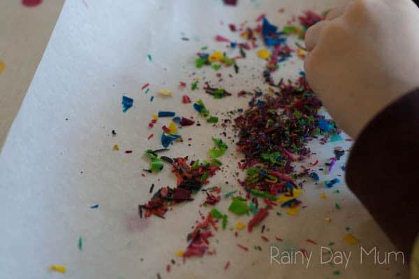 Process Art project for kids using crayons - create beautiful stained glass effect shapes using crayon shavings and scissor skills.