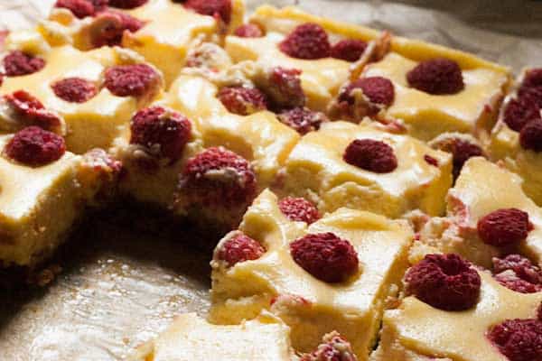 Delicious easy summer dessert recipe for Raspberry and Vanilla Cheesecake Bars with a gingernut crust. Ideal for BBQ's, potlucks and picnics.