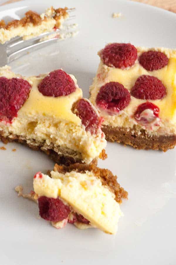 Delicious easy summer dessert recipe for Raspberry and Vanilla Cheesecake Bars with a gingernut crust. Ideal for BBQ's, potlucks and picnics.