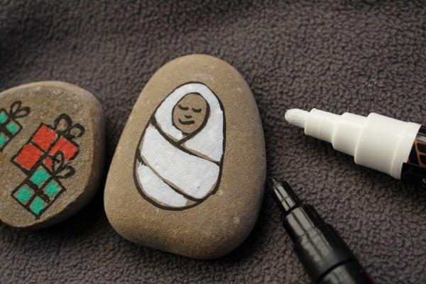 using pens to decorate stones to create a set of story stones for retelling the nativity story with kids