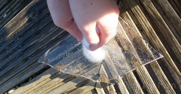 hands sprinkling salt onto a piece of ice