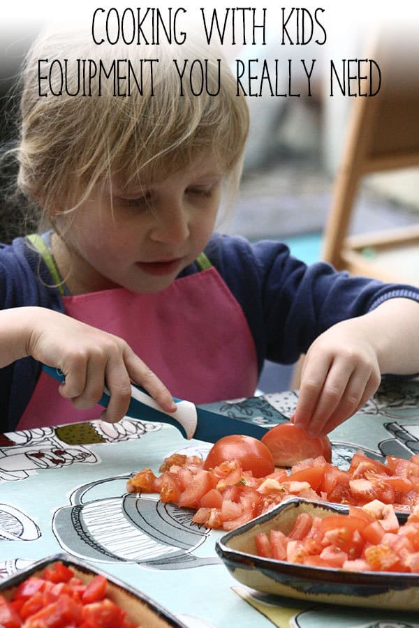Toddler using a knife to cut tomatoes