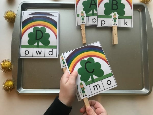 preschooler clipping the matching lowercase letter to the uppercase letter on a St Patrick's Day Themed Alphabet clip card activity