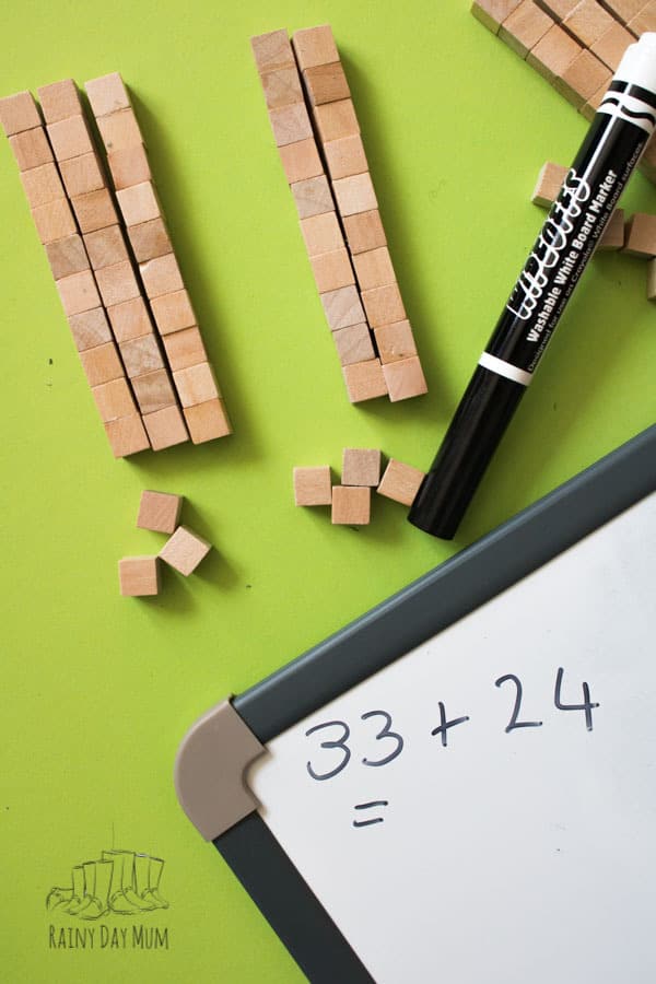 homemade wooden tens and units blocks being used with a white board to do some addition with a home educated primary child