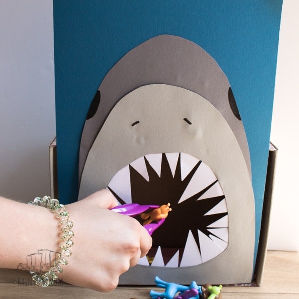 DIY Math Game for toddler sand preschoolers to feed the hungry shark. Count, sort and feed the shark in this fun Shark Week learning activity for young children.