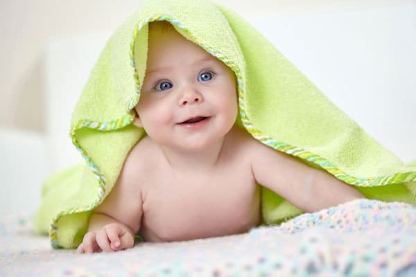 4 month old under a green towel