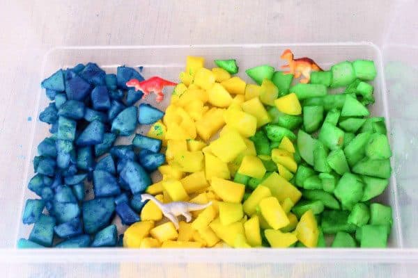 setting up a dinosaur sensory bin for toddlers that put everything in their mouth