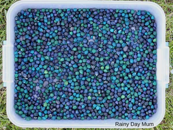 Easy to set up coloured dried chickpea sensory bin filler for a space theme