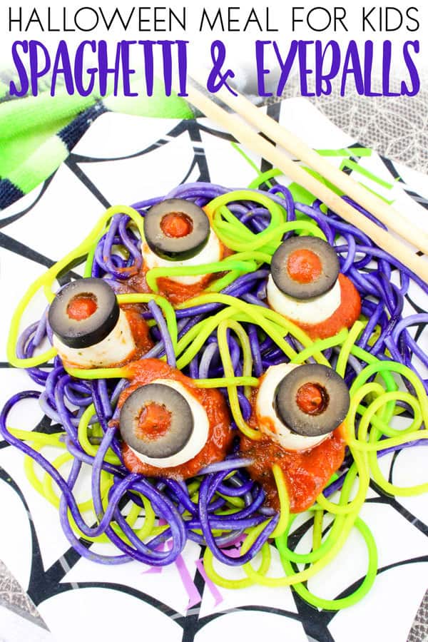 A spooky meal of Spaghetti and eyeballs colored for Halloween with geen and purple spaghetti and cheese and olive eyeballs