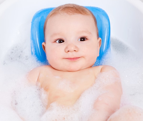 6 month old baby in the bath having fun and experiencing different sensations.