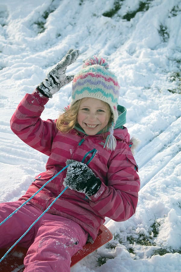 Picture of a young girl sledging in the snow