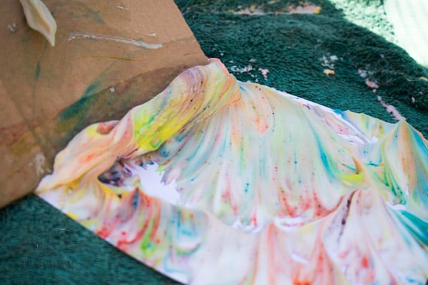 removing shaving foam from paper a step in the process of creating shaving foam marbling with kids
