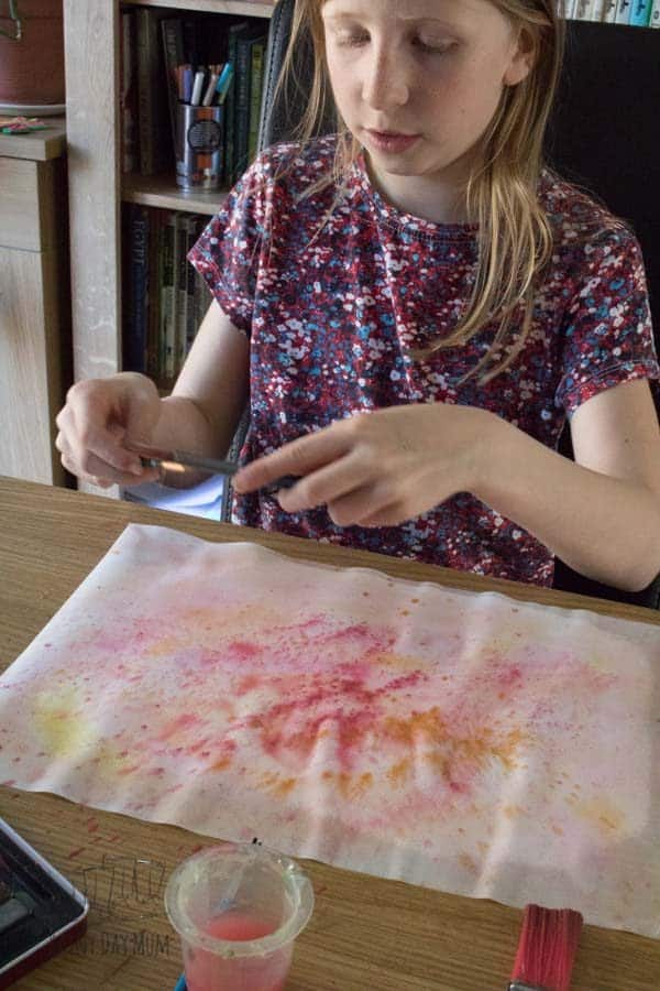 splatter painting with warm colours on a watercolor wash
