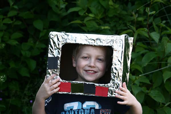 Child wearing space helmet they have made with simple materials in the junk model box