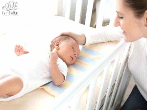 newborn baby in a cot with mother