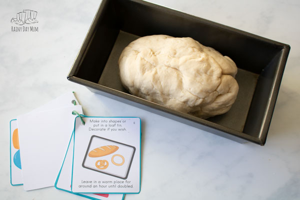 flip through recipe booklet for easy bread dough from rainy day mum next to a loaf tin with bread dough ready to rise.