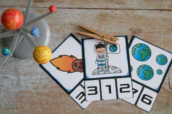 3 space themed count and clip cards with a peg and a model of the solar system