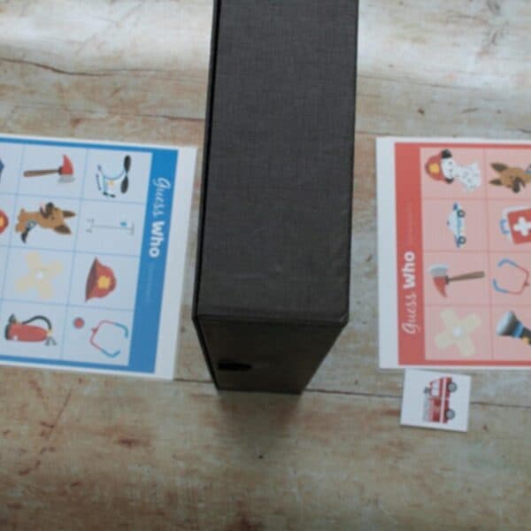 laminated game boards with a divider between for a FREE printable Guess Who Emergency Services game for preschoolers