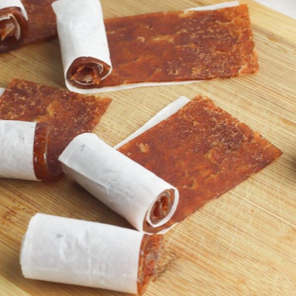 apple and cinnamon fruit leathers on a wooden chopping board