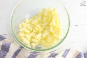 diced apple with lemon juice and zest in a pyrex bowl on a table
