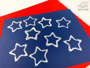 toddler printed stars on a blue paper laid on a red a fun easy craft for 4th of July to make a placemat that is unique for each family member