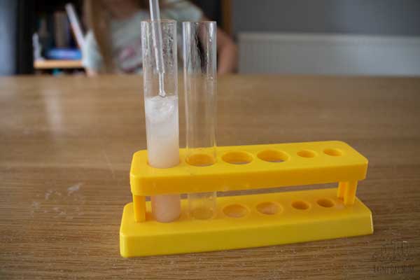adding isopropyl alcohol to a test tube to extract DNA from a banana