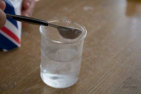 adding table salt to a beaker of water