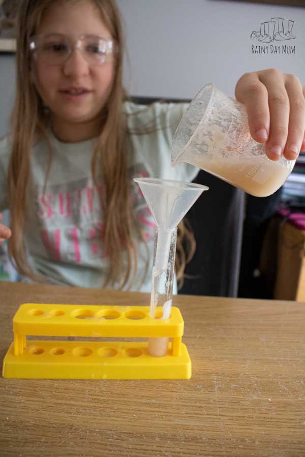child filling a test tube with banana dna extraction liquid