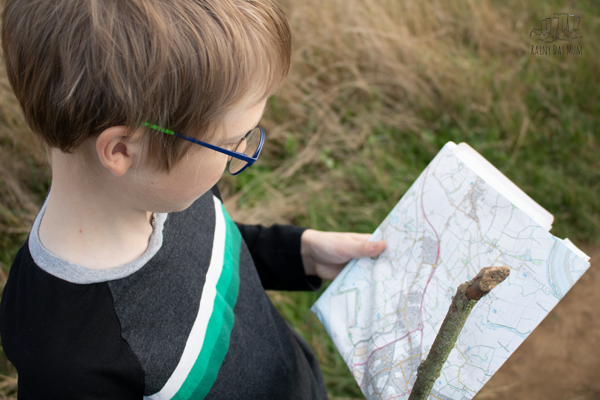 boy checking a map that has been used to plan a route for an orienteering adventure as a family
