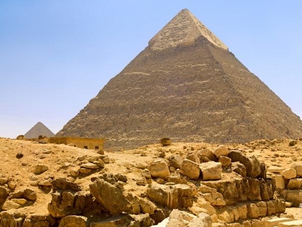 one of the pyramids at giza in egypt with a pile of blocks infront