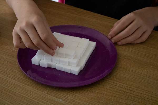 layering the squares of sugar cubes to make a pyramid for an ancient egyptian lesson