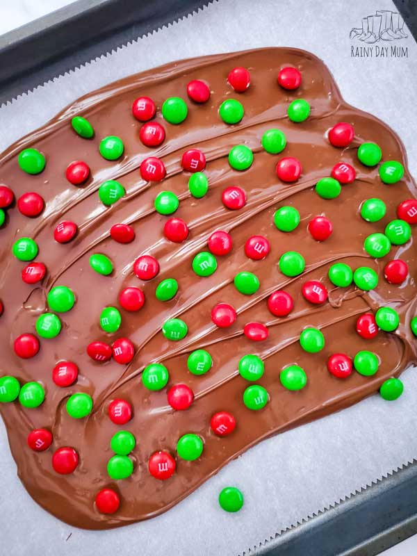 chocolate bark with Christmas M&Ms sprinkled on the top ready to set