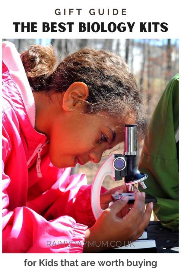 Pinterest image for a Gift Guide of The Best Biology Kits for Kids that are worth buying image shows a girl using a microscope outdoors to look at specimens