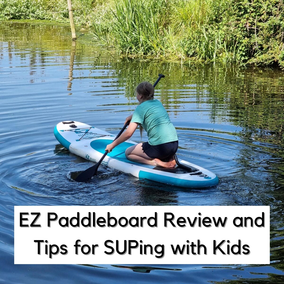 Square image of a teen on a paddleboard kneeling on a river in the UK. Text reads EZ Paddleboard Review and Tips for SUPing with Kids.