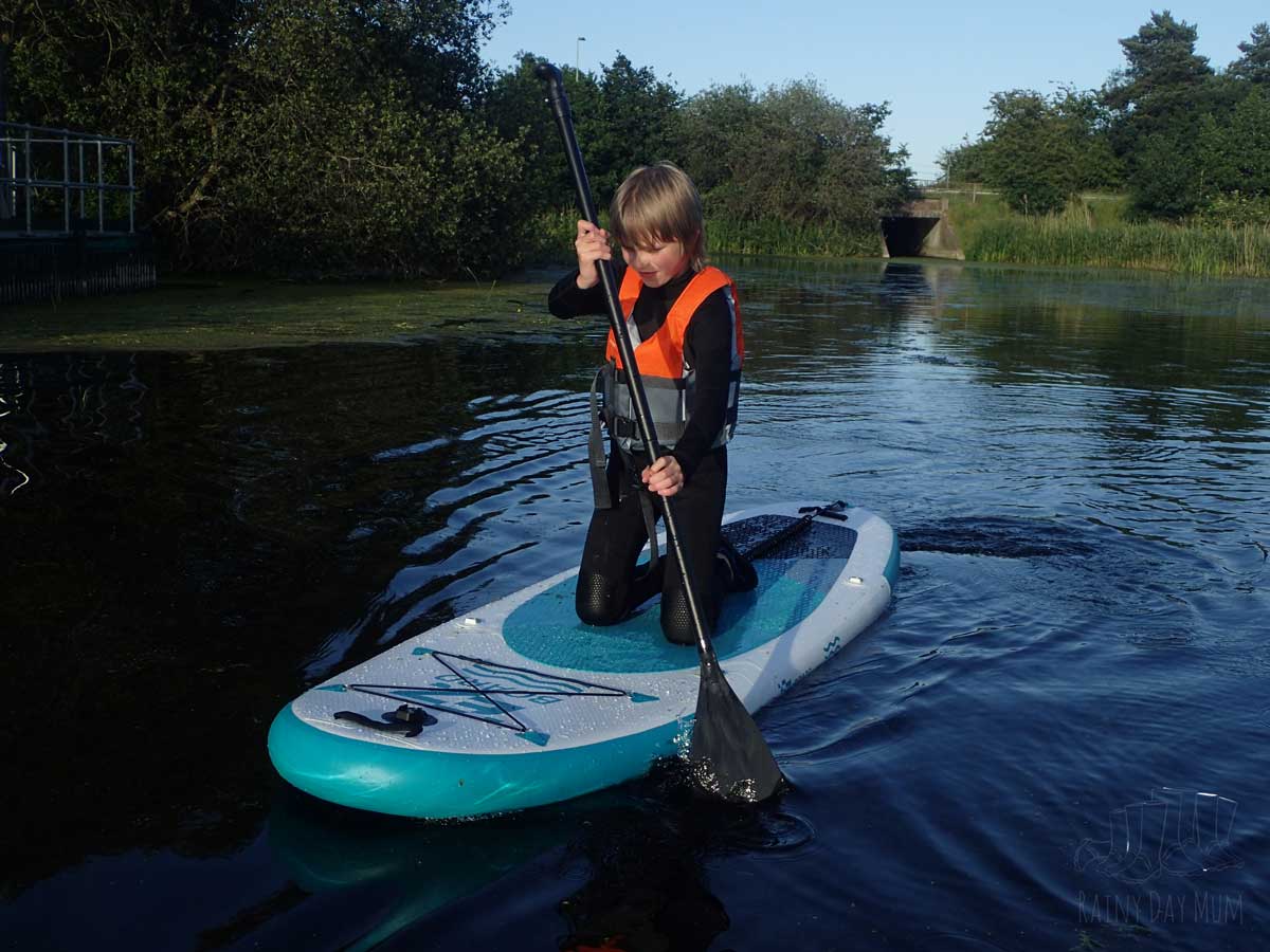 Tween paddleboarding in the UK on a river.